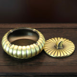 Covered metal ashtray with lid open showing deep bowl for cigarettes