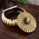 Brass ashtray with lid holding cigarette odor control indoor use