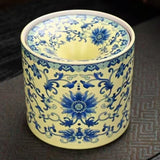 Cylindrical ceramic ashtray with blue floral patterns and a funnel lid