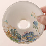 Hand holding a ceramic lid with artistic designs
