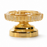 Amber faceted glass ashtray with metal stand on white background