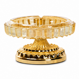 Amber faceted glass ashtray with ornate gold metal stand on white background