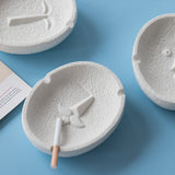 White ceramic face ashtray on blue background, modern artistic product photo