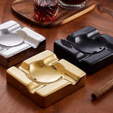 Three metallic ashtrays in gold, silver, and black