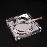 Clear crystal glass ashtray square with cigarette minimalist background