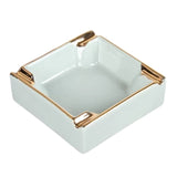 Ivory white ceramic ashtray with gold accents and 4 grooves to rest cigarettes
