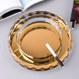 Gold round glass ashtray with cigarette top view luxury finish