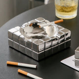 Modern silver cube ashtray lifestyle photo with cigarette and drink, decorative square tabletop ashtray