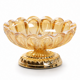 Amber scalloped glass ashtray with ornate gold metal base on white background