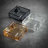 Three glass square ashtrays in different colors each with 2 cigarette rests