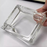 Clear glass square dish held by a hand to show details