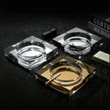 Multiple crystal glass ashtrays gold and clear on modern black surface