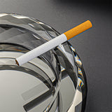Clear glass ashtray groove detail holding cigarette close up