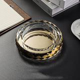 Gold round glass ashtray on table modern home setting